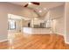 Open concept layout with hardwood floors, white kitchen cabinets, and stainless steel appliances at 2628 Spruce Creek Blvd, Port Orange, FL 32128