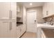 Bright laundry room with white cabinets, countertop, and modern washer and dryer at 2628 Spruce Creek Blvd, Port Orange, FL 32128