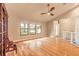 Spacious living area with hardwood floors, a ceiling fan, and natural light from large windows at 2628 Spruce Creek Blvd, Port Orange, FL 32128
