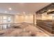 Open living area with stained concrete floors, doors to the exterior and a custom bar at 2628 Spruce Creek Blvd, Port Orange, FL 32128