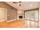 Living area with hardwood floors, a white brick fireplace, and access to the backyard at 2628 Spruce Creek Blvd, Port Orange, FL 32128