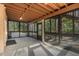 Enclosed and screened porch with a view of lush green surroundings and a tiled floor at 2628 Spruce Creek Blvd, Port Orange, FL 32128