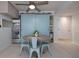 Dining area with round table, blue chairs, and a barn door leading to the pantry at 2800 N Atlantic Ave # 1715, Daytona Beach, FL 32118