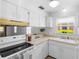 Functional kitchen with bright cabinets, sleek appliances, and a view from the window at 3 Fairway Ct, Deland, FL 32724