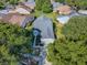 Aerial view of a well-maintained single-Gathering home with lush landscaping, a gray roof, and a paved driveway at 307 Stonington Way, Deland, FL 32724