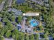 Aerial view of the community clubhouse and recreation center featuring a pool, tennis courts, and lush landscaping at 307 Stonington Way, Deland, FL 32724