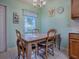 Eat-in kitchen with a dining table set by a bright window and light green walls at 307 Stonington Way, Deland, FL 32724