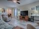 Bright living room boasts hardwood floors and a large entertainment center at 307 Stonington Way, Deland, FL 32724