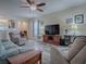 Comfortable living room featuring a ceiling fan, a large TV, and cozy furniture for relaxation and entertainment at 307 Stonington Way, Deland, FL 32724