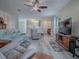 Open living room offers wood flooring, ceiling fan, and lots of natural light at 307 Stonington Way, Deland, FL 32724