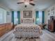 Relaxing main bedroom features a bed with floral pattern, wood furniture and bright window light at 307 Stonington Way, Deland, FL 32724