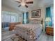 A bedroom with light-colored wood floors, access to screened patio, and a floral bedspread at 307 Stonington Way, Deland, FL 32724