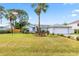 A single-story home with manicured front lawn, swaying palm tree, and an American flag at 3214 Juniper Dr, Edgewater, FL 32141