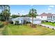 Charming single-story home boasts a lush front yard with a palm tree and American flag at 3214 Juniper Dr, Edgewater, FL 32141