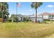 A single-story home with manicured front lawn, swaying palm tree, and an American flag at 3214 Juniper Dr, Edgewater, FL 32141