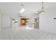 Spacious living room with bright white tile flooring and an abundance of natural light from windows and skylight at 3214 Juniper Dr, Edgewater, FL 32141