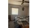 Bedroom features a ceiling fan, window with blinds, and minimal furnishings at 326 South St, De Leon Springs, FL 32130