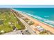 Aerial view of beach homes along the coast near a golf course and main road at 33 Ocean Shore Blvd, Ormond Beach, FL 32176