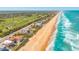 Expansive aerial view featuring beachfront properties, golf courses, and the beautiful coastline at 33 Ocean Shore Blvd, Ormond Beach, FL 32176