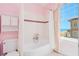 Pink bathroom with a tub, tile accents, and a view of the ocean at 33 Ocean Shore Blvd, Ormond Beach, FL 32176