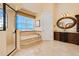 Bright bathroom featuring dual vanity, walk-in shower, soaking tub, and beach views at 33 Ocean Shore Blvd, Ormond Beach, FL 32176