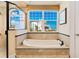 Luxurious bathroom featuring a soaking tub with ocean views and a glass shower at 33 Ocean Shore Blvd, Ormond Beach, FL 32176