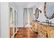Bathroom with dual vanities, ornate mirrors, and a mirrored closet at 33 Ocean Shore Blvd, Ormond Beach, FL 32176