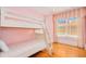 Pink bedroom featuring a bunk bed, hardwood floors, and window with decorative curtains at 33 Ocean Shore Blvd, Ormond Beach, FL 32176