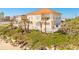 Beautiful home nestled on a grassy hill with palm trees and a white picket fence near the beach at 33 Ocean Shore Blvd, Ormond Beach, FL 32176