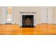 Close up on living room fireplace and hardwood floors with an adjacent doorway at 33 Ocean Shore Blvd, Ormond Beach, FL 32176
