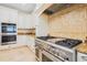 Gourmet kitchen with stainless steel appliances, granite countertops, custom cabinets, and a modern backsplash at 33 Ocean Shore Blvd, Ormond Beach, FL 32176