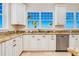 Kitchen showcasing stainless steel appliances, granite countertops, custom cabinets, and ocean view at 33 Ocean Shore Blvd, Ormond Beach, FL 32176