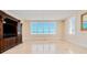 Spacious living room featuring tile floors, a large picture window with ocean view, and a decorative entertainment center at 33 Ocean Shore Blvd, Ormond Beach, FL 32176