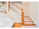 Elegant staircase with hardwood steps, white railings, and a sitting area at 33 Ocean Shore Blvd, Ormond Beach, FL 32176