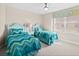 Cozy bedroom with two beds, a ceiling fan, and natural light, perfect for a peaceful retreat at 3311 S Atlantic Ave # 1704, Daytona Beach Shores, FL 32118