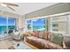 Inviting living area featuring tropical-patterned sofa and ample natural light from the expansive ocean-view windows at 3311 S Atlantic Ave # 1704, Daytona Beach Shores, FL 32118