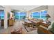 Bright living room with ocean views through sliding glass doors and windows, plus tropical-themed furniture at 3311 S Atlantic Ave # 1704, Daytona Beach Shores, FL 32118