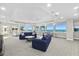 Comfortable lounge area with plush sofas, multiple windows showcasing scenic ocean views, and ceiling fans at 3311 S Atlantic Ave # 1704, Daytona Beach Shores, FL 32118