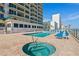 Pool and spa area with lounge chairs, palm trees, and ocean views, offering a resort-style experience at 3311 S Atlantic Ave # 1704, Daytona Beach Shores, FL 32118