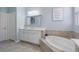 Clean bathroom featuring an oversized soaking tub, vanity with sink, and neutral color palette at 3451 Luna Bella Ln, New Smyrna Beach, FL 32168