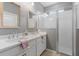Bathroom with double vanity, neutral paint, bright lighting, and shower with glass door at 3451 Luna Bella Ln, New Smyrna Beach, FL 32168