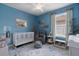 Blue baby bedroom with crib, changing station, chair and a window at 3451 Luna Bella Ln, New Smyrna Beach, FL 32168