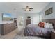 Spacious main bedroom with en-suite bathroom, wood-look floors, ceiling fan, and lots of natural light at 3451 Luna Bella Ln, New Smyrna Beach, FL 32168