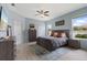 Comfortable main bedroom with wood-look floors, ceiling fan, and ample natural light from two windows at 3451 Luna Bella Ln, New Smyrna Beach, FL 32168
