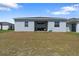 Rear exterior view of the house featuring a covered patio and backyard at 34568 Shellback St, Leesburg, FL 34788