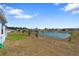 Spacious backyard featuring a scenic pond view, grass, and trees at 34568 Shellback St, Leesburg, FL 34788