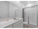 Bright bathroom featuring a glass door shower, large mirror, and quartz countertop vanity at 34568 Shellback St, Leesburg, FL 34788