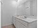 Bathroom with double sinks, large mirror, white cabinets and tile flooring at 34568 Shellback St, Leesburg, FL 34788