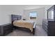 Bedroom with window, carpet and a dark wood-trimmed bed with side tables at 34568 Shellback St, Leesburg, FL 34788