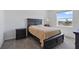 Bedroom with window, carpet and a dark wood-trimmed bed with side tables at 34568 Shellback St, Leesburg, FL 34788